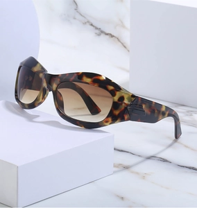 Detail of tortoise shell sunglasses with brown gradient lenses on white cubes