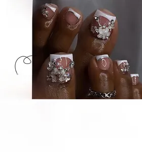 Detail view of French-style toe nails featuring 3D flowers, pearls, and bows on pink base