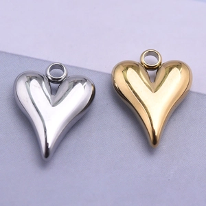 Detailed view of polished irregular heart-shaped pendants in gold and silver finish