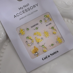Detail of floral nail jewelry with yellow rhinestones and silver metal frames