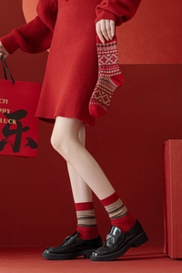 Détail de chaussettes en laine rouge avec motif tricoté Fair Isle épais et flocon de neige