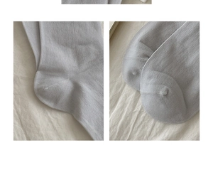 Detail of grey silk socks showing the seamless toe and heel stitching on white fabric