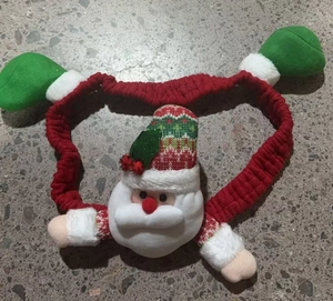 Detail of Christmas headband with 3D Santa plush, red velvet fabric and green pom-poms