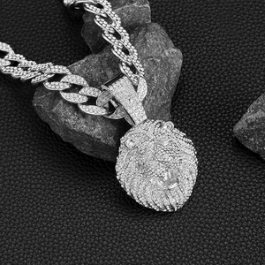 Gros plan détaillé du pendentif lion argenté sur une chaîne à maillons cubains en cristaux