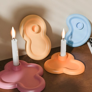 Artistic pastel matte ceramic candle holders in wavy organic shapes for home decor