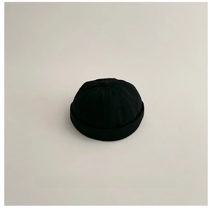 Dettaglio del berretto docker nero in tela con ricamo Unice bianco e struttura a sei pannelli