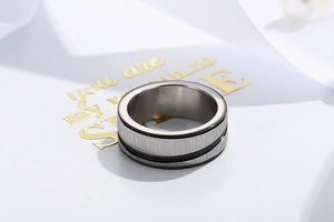 Macro detail of brushed stainless steel ring with dual black grooves and polished inner band