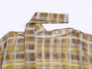 Detail von gelb-weißem Karo-Chiffon-Stoff mit halbtransparenter Textur und Musterung