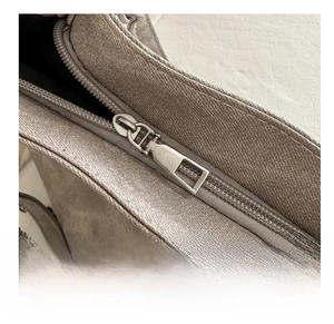 Close-up of the smooth metal zipper detail on the earthy frosted tote bag