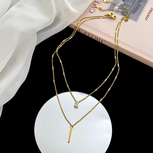 Elegant gold double layer necklace with teardrop crystal and vertical bar pendants