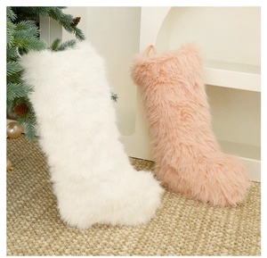Close-up of white and pink plush Christmas stockings hanging with cozy holiday decor