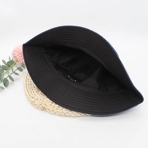 Close-up of the interior lining and stitching detail on a black cotton bucket hat