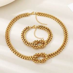 Detailed close-up of double-layered gold stainless steel knot necklace and bracelet set