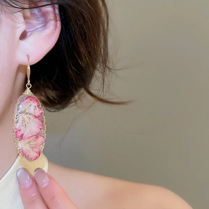 Elegantes pendientes ovalados de resina hechos a mano con flores secas rojas reales