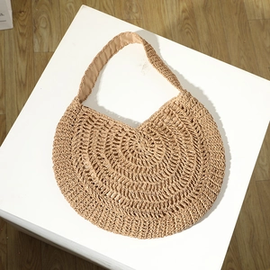 Large beige woven straw tote bag in a half-moon shape for women's beach vacations