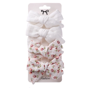 Detail of 4-piece set featuring white and pink floral cotton bow hair clips on card