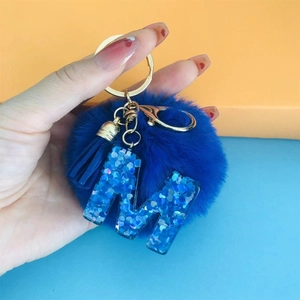 Blue pompom keychain with blue sequin letter M and gold metal ring for bags