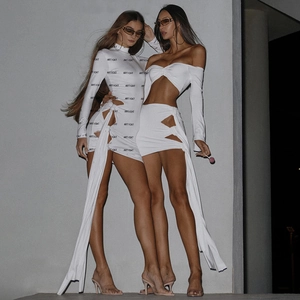 Détail d'une robe blanche à manches longues avec imprimé ARTICAT et lacets ajourés