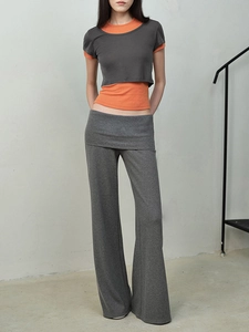 Détail d'un haut court superposé orange et gris avec un pantalon large gris assorti