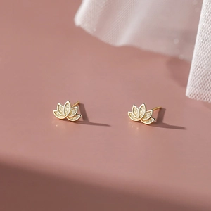 Elegant gold S999 silver lotus flower stud earrings on a soft pink background