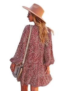 Rear view of a red A-line long sleeve dress with white polka dots and a wide brim hat