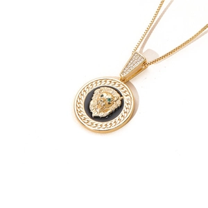 Pendentif tête de lion avec yeux en gemme verte sur base noire et chaîne dorée