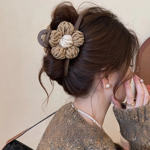 Pince à cheveux fleur tricotée beige et marron portée par un mannequin à l'arrière