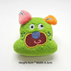 Front view of green cartoon dog plush accessory, height 6cm and width 6.5cm with embroidery