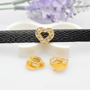 Macro detail of gold-plated heart sliders with pavé zircons for DIY jewelry wristbands