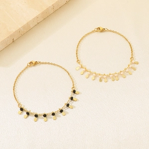 Elegant gold chain bracelet with colorful beads and water drop pendants on stone