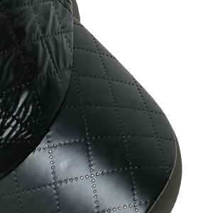 Detailed macro view of black faux leather baseball cap featuring diamond quilted stitching