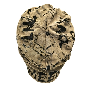 Close-up of khaki beanie featuring retro distressed holes and black letter print details