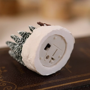 Detailed view of the battery compartment and power switch on the Christmas resin house base