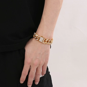 Close-up of hip-hop iced out Cuban link bracelet in gold finish worn by a model