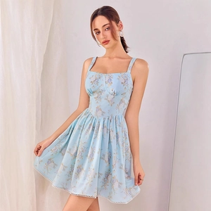 Détail d'une robe bleu clair à fleurs avec décolleté en cœur et fines bretelles