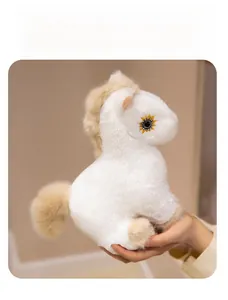 Detail of soft white plush horse toy featuring golden sunflower eye embroidery