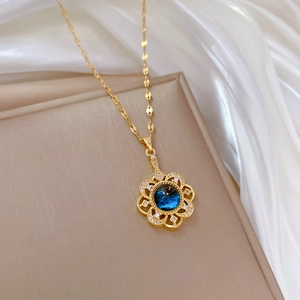 Elegant gold titanium steel necklace with blue floral starburst pendant on silk cloth