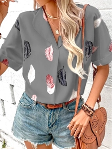 Detail of summer short sleeve shirt with grey base and colorful feather print pattern