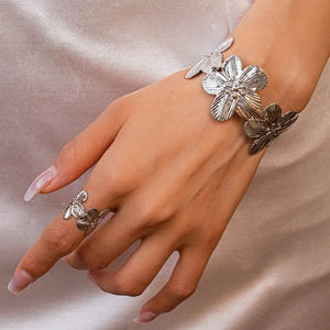 Detailed view of silver flower cuff bracelet and ring set with textured petals