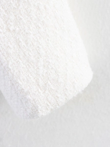 Dettaglio macro della trama del tessuto in tweed bianco di una giacca chic
