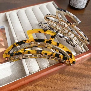 Elegant acetate and gold metal shark hair claws in tortoise and marble patterns