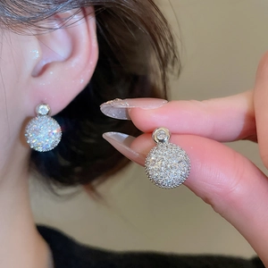 Detail view of silver S925 stud earrings with spherical pave-set cubic zirconia stones