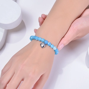 8mm blue weathered agate stone bracelet with silver heart charm on model wrist