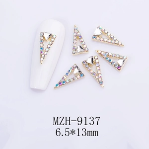 Dettaglio macro di strass per unghie a triangolo cavo 6,5x13mm con lega dorata e pietre