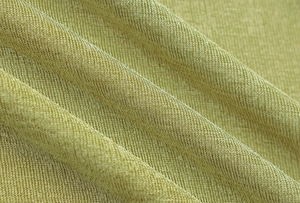 Vue macro d'un tissu texturé vert citron montrant le tissage fin et le drapé doux