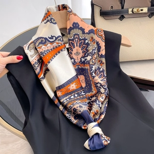 Detail of silk-like scarf with vintage paisley pattern in navy and orange tones