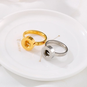 Golden and silver stainless steel rings with concave circular design on a white ceramic plate