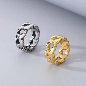 Close-up of silver-black and gold stainless steel rings with Cuban chain link patterns