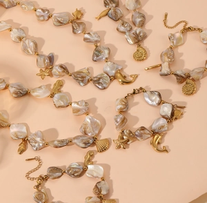 Close-up of beach jewelry with pearl beads, golden starfish and seahorse pendants