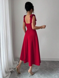 Detail van rode mouwloze midi-jurk met onzichtbare rits en strikjes op de schouders